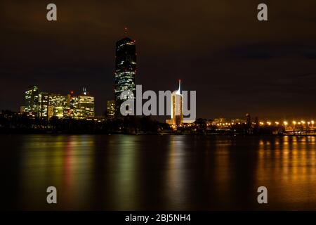 Lo skyline della Nuova Vienna si riflette nel Danubio di notte, Vienna, bassa Austria, Austria Foto Stock