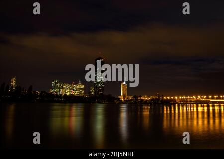 Lo skyline della Nuova Vienna si riflette nel Danubio di notte, Vienna, bassa Austria, Austria Foto Stock