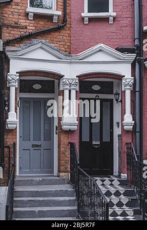 Porte d'ingresso nere e grigie su una facciata di case a schiera inglesi tradizionali a West Hampstead. Hampstead ha alcuni degli alloggi più costosi i Foto Stock