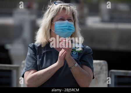 Kansas City, Stati Uniti. 28 Aprile 2020. I membri del personale del Research Medical Center reagiscono a un volo da parte degli Stati Uniti Air Force B-2 Spirit Bombardieri, insieme ai T-38 Talons Fighters e A-10 Thuderbolt Aircraft durante il volo americano strong 28 aprile 2020 a Kansas City, Missouri. America strong è un saluto della Marina militare e dell'Aeronautica militare per riconoscere gli operatori sanitari, i soccorritori e altri membri essenziali del personale in una dimostrazione di solidarietà nazionale durante la pandemia COVID-19. Credito: Kayla White/U.S. Air Force/Alamy Live News Foto Stock