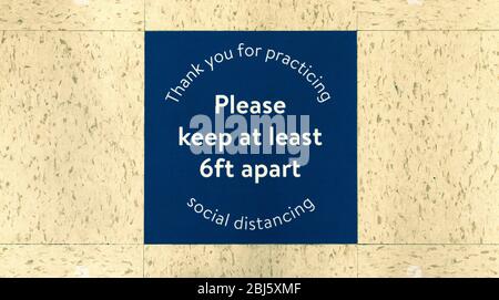 Cartello quadrato di distanziamento sociale sul piano del supermercato Foto Stock