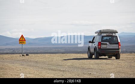 Il SUV si fermò di fronte al cartello stradale nelle alture Dell'Islanda Foto Stock