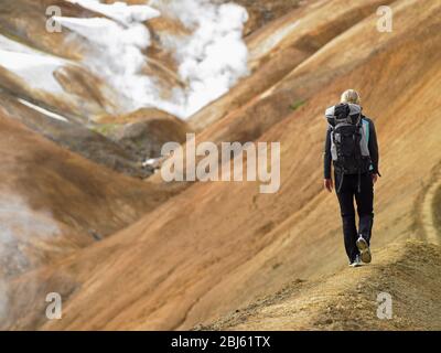 Giovane donna che camminano lungo il crinale negli altopiani islandesi Foto Stock