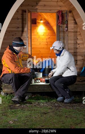 coppia che prepara il cibo di fronte al pod campeggio nel REGNO UNITO Foto Stock