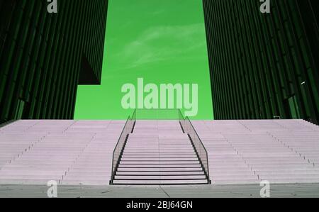 Moderna scala con corrimano nel mezzo che salirà sul verde sfondo, edificio di uffici Foto Stock