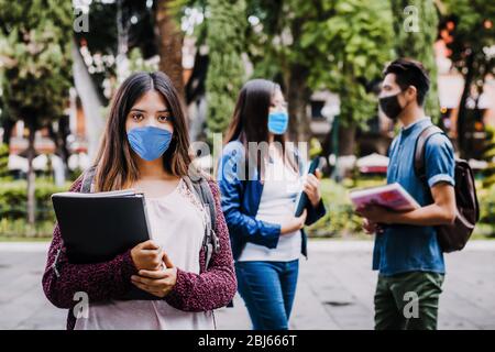 ragazza messicana studente che indossa maschera viso per prevenire le infezioni o malattie respiratorie, Latino con protezione contro coronavirus contagioso in Mex Foto Stock