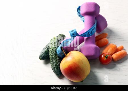 Manubri con frutta e verdura sane su sfondo chiaro Foto Stock