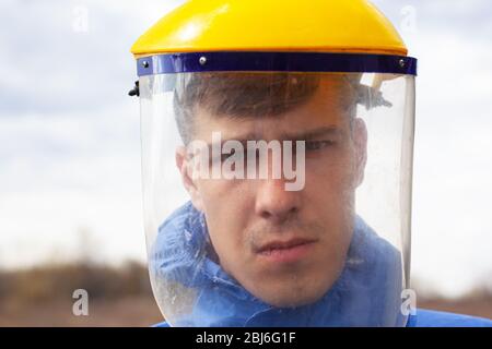 giovane uomo in plastica protettiva maschera medica primo piano in piedi sulla strada. Foto Stock