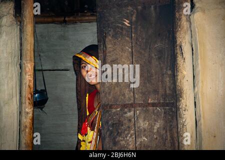 Donna rurale in piedi alla porta di casa Foto Stock