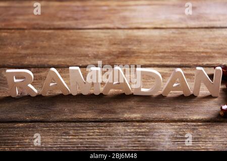 Immagine della parola RAMADAN e datteri frutta su sfondo legno, primo piano Foto Stock