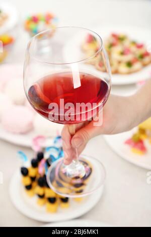 Donna che tiene il wineglass su sfondo del buffet Foto Stock