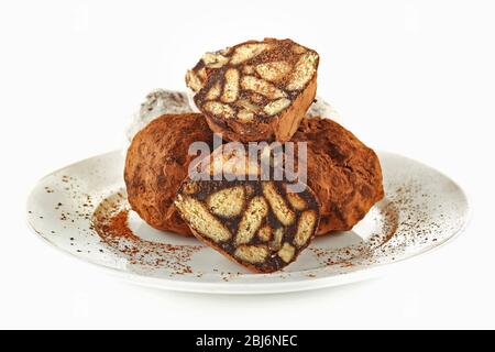 Caramelle al salame di cioccolato con cacao in polvere, isolate su bianco Foto Stock