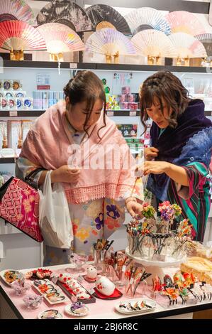 Gli acquirenti in un negozio all'interno del mercato alimentare Nishiki a Kyoto in Giappone. Foto Stock