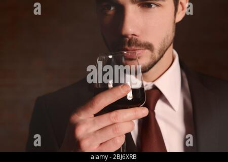 Uomo che sniffa vino rosso in bicchiere Foto Stock