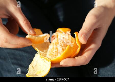 Donna mano peeling maturo dolce mandarino, primo piano Foto Stock