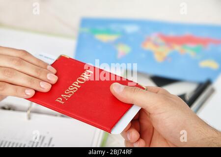 Agente che consegna passaporto e biglietto al cliente nell'ufficio della compagnia di viaggio Foto Stock