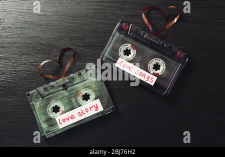 Cassette audio retro con nastri a forma di cuore su sfondo in legno Foto Stock