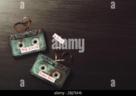 Cassette audio retro con nastri a forma di cuore su sfondo in legno Foto Stock