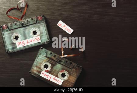 Cassette audio retro con nastri a forma di cuore su sfondo in legno Foto Stock