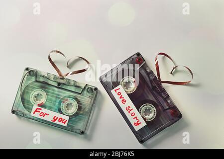 Cassette audio retro con nastri a forma di cuore su sfondo bianco Foto Stock