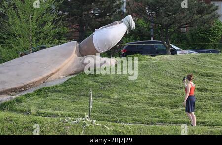 St. Louis, Stati Uniti. 28 Aprile 2020. Una donna si ferma per scattare una foto di Tom la tartaruga con una nuova maschera facciale su, in Turtle Park, a St. Louis il Martedì 28 aprile 2020. Il parco e tutti i parchi giochi della città sono stati chiusi al pubblico per oltre un mese, a causa delle paure del coronavirus. Foto di Bill Greenblatt/UPI Credit: UPI/Alamy Live News Foto Stock