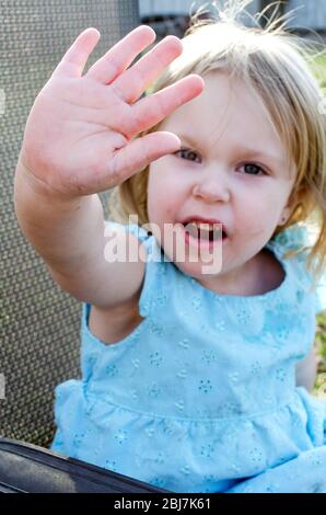 La ragazza giovane tiene una mano per mostrare la mamma che ha veramente lavato le mani ed è pulito. Beh, quasi! Foto Stock