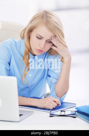 Donna stanca al notebook in ufficio Foto Stock