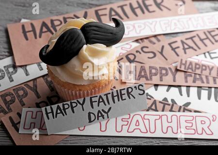 Buon giorno dei padri speciale cupcake con baffi su tavolo di legno Foto Stock