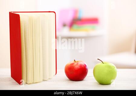 Libri e mela sul tavolo, primo piano Foto Stock