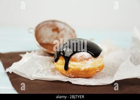 Deliziosa ciambella con cioccolato sul primo piano di pergamena Foto Stock