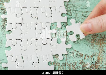 Donna che gioca con puzzle su tavolo di legno Foto Stock
