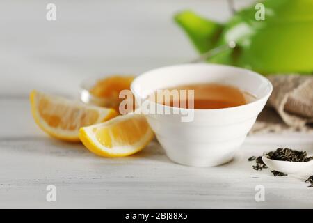 Bicchiere di tè verde con limone su tavolo di legno primo piano Foto Stock