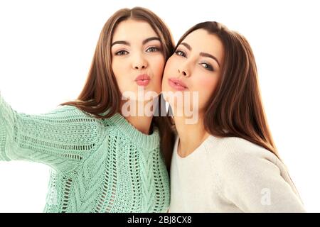 Due ragazze adolescenti che fanno la foto da loro stessi, isolato su bianco Foto Stock