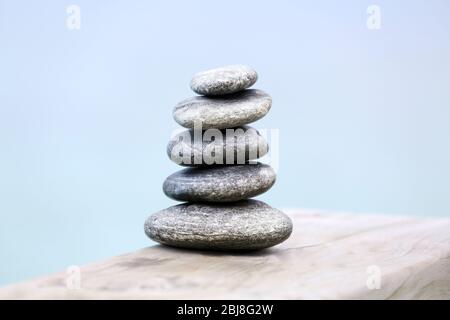 Pila di pietre termali su ponte di legno Foto Stock