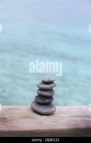 Pila di pietre termali su ponte di legno Foto Stock