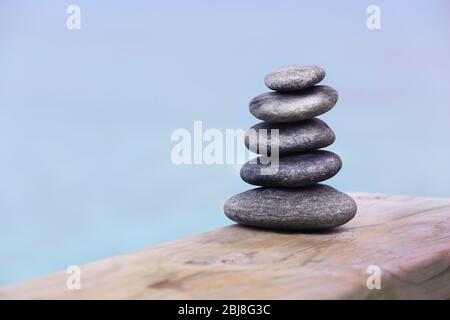 Pila di pietre termali su ponte di legno Foto Stock