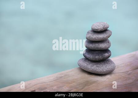Pila di pietre termali su ponte di legno Foto Stock