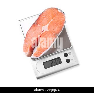 Fila di bistecca di salmone su scala digitale da cucina, isolato su bianco Foto Stock