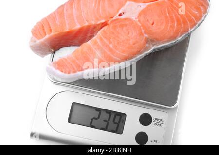 Fila di bistecca di salmone su scala digitale da cucina, isolato su bianco Foto Stock