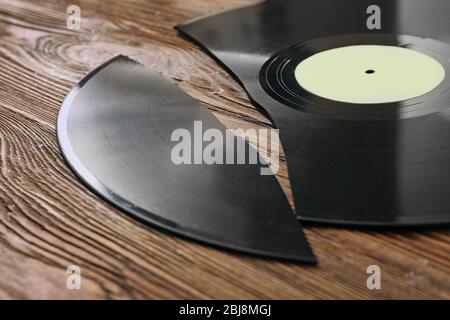 Rotto vecchio disco di vinile su sfondo di legno Foto Stock