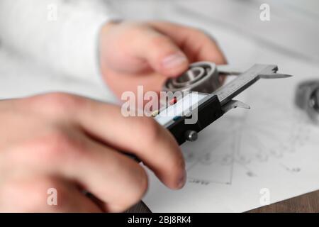 Mani maschi per la misurazione dei dettagli in metallo primo piano Foto Stock