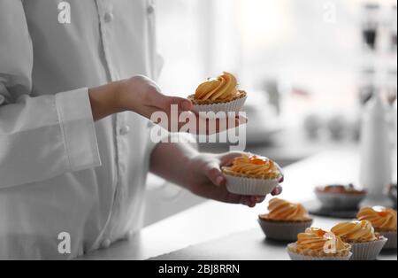 Mani femminili che tengono le torte appena fatte Foto Stock