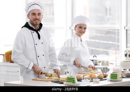 Chef che tagliano la banana su un asse di legno. Foto Stock