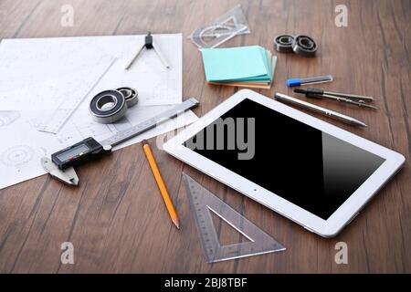 Tablet e strumenti di progettazione su sfondo di legno Foto Stock