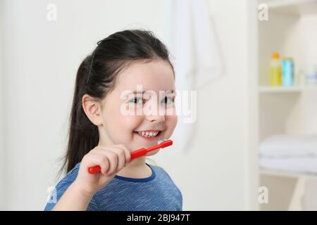 Sorridente ragazza che sfrega i denti, primo piano Foto Stock