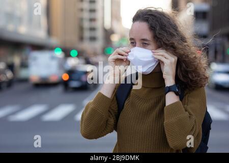 Donna caucasica che indossa una maschera protettiva Foto Stock