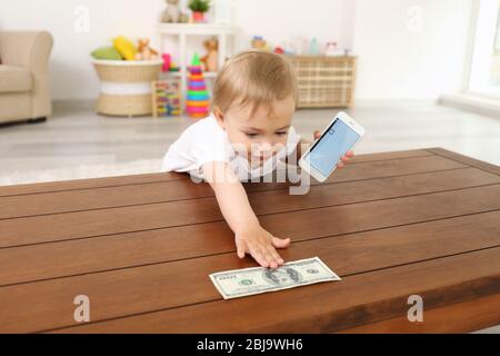 Ragazza cute del bambino che raggiunge per un dollaro fattura Foto Stock