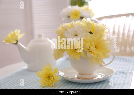 Bouquet di fiori di crisantemo in tazza su tovagliolo blu Foto Stock