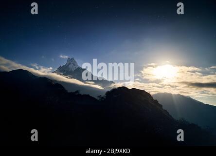 Snowy Machapuchare racconto di pesce mountain durante la notte cielo stellato nel santuario di Annapurna del Nepal Foto Stock