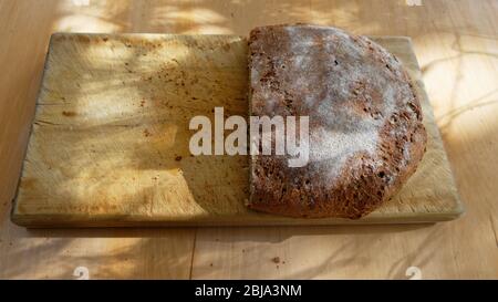 Il pane appena sfornato è pronto per mangiare, è stato servito su un pannello di legno Foto Stock